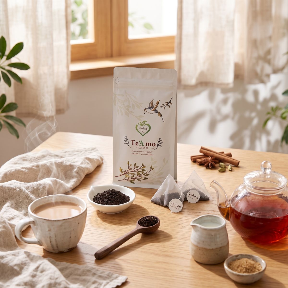 晨光灑落木桌上的 Te'Amo 錫蘭奶茶包包裝袋、現煮熱奶茶與清透玻璃茶壺雜貨風擺設