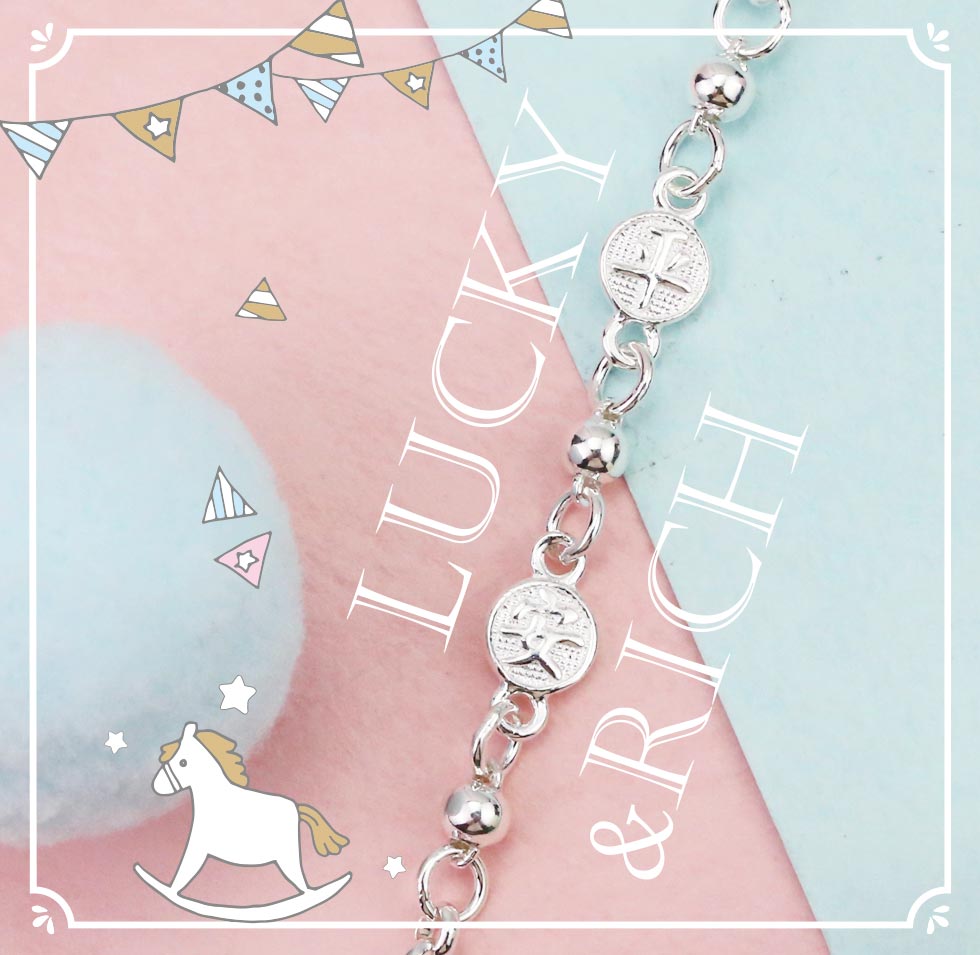 銀質手鍊平鋪展示,文字LUCKY & RICH呼應祝福感。