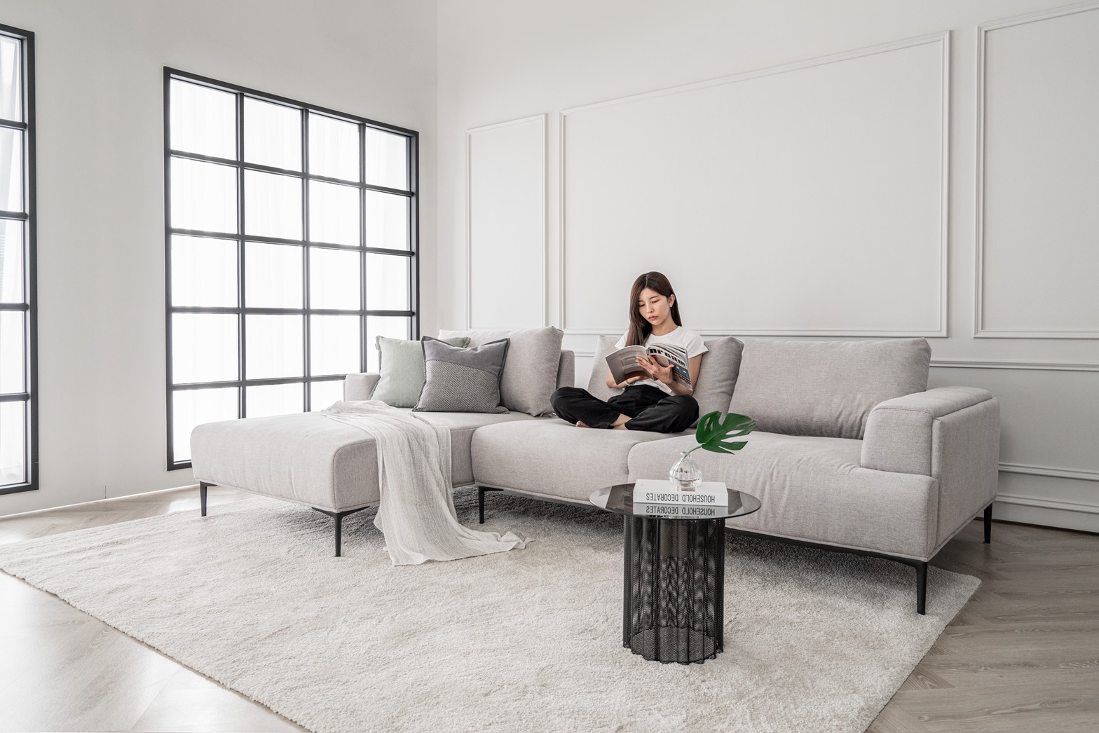 躺躺沙發使用情境 一位傢配師正在盤腿坐在躺躺沙發上,看著書