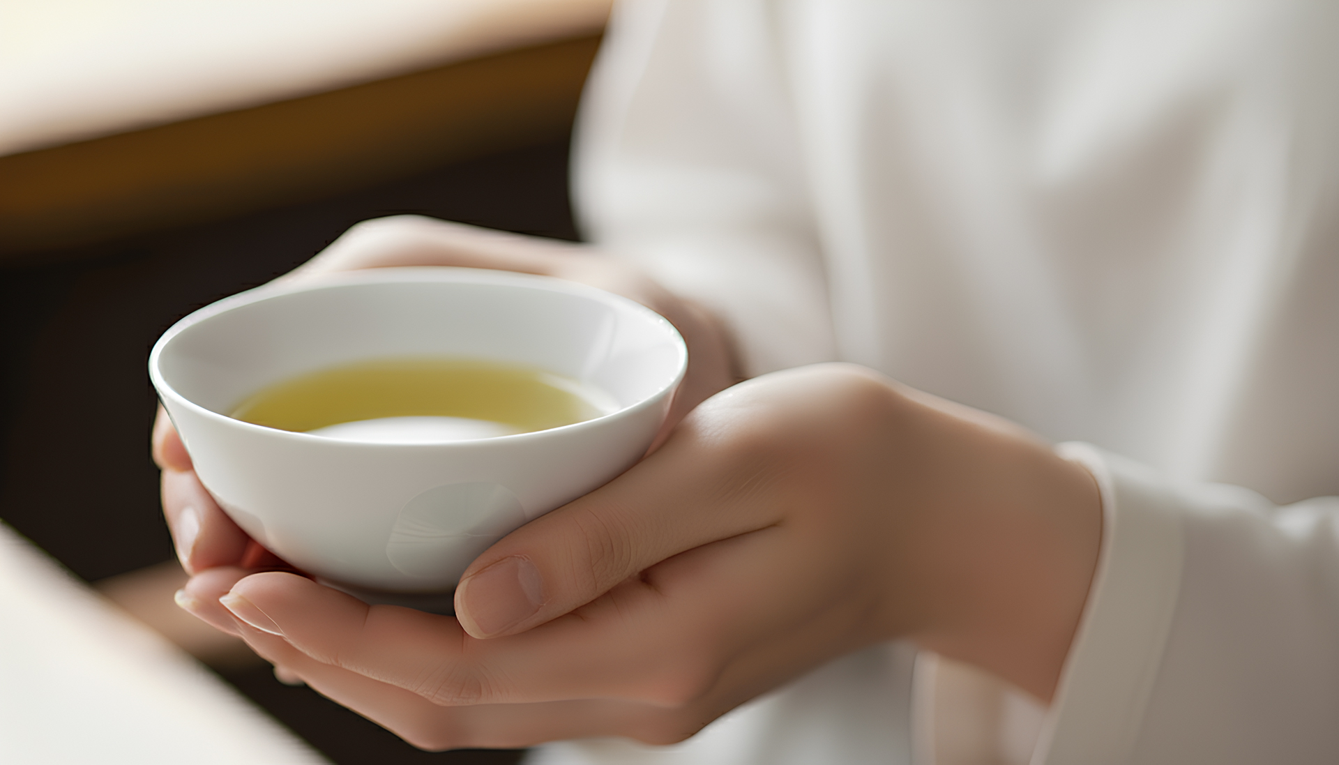 手持特寫:雙手手捧綠色結晶釉茶杯,強調溫潤質感。