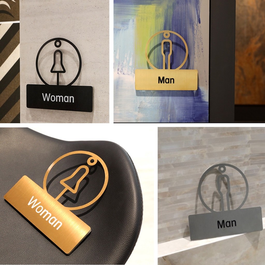 不鏽鋼廁所標示牌安裝在牆面與門板上的實景:金色 Woman 與黑色 Man 標示