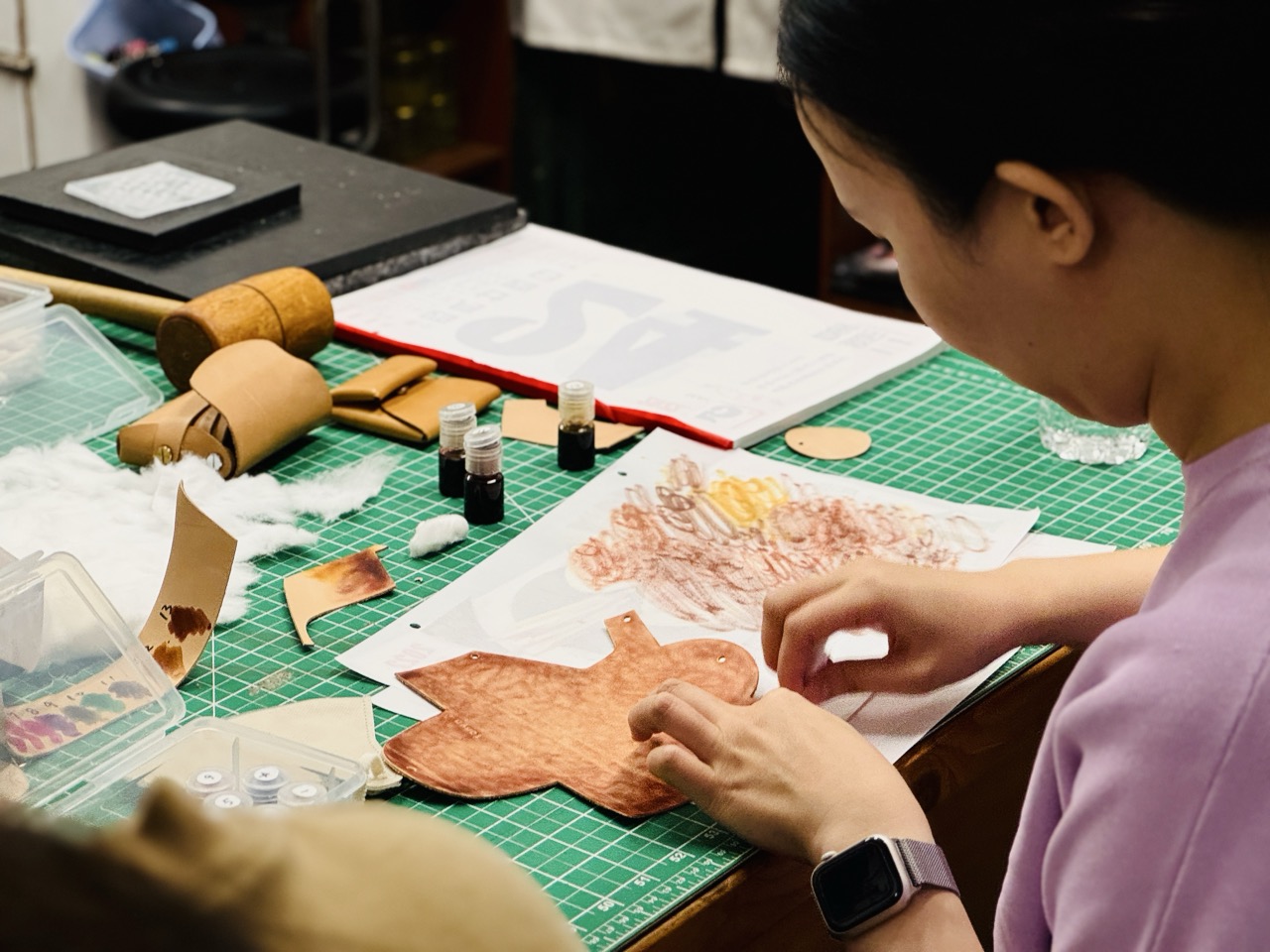 老師於皮革課程中協助學員調整皮革染色操作細節與製作手法