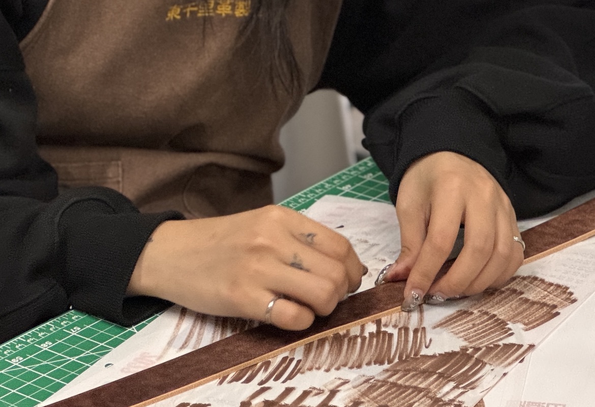 老師於皮革課程中協助學員調整皮革染色操作細節與製作手法