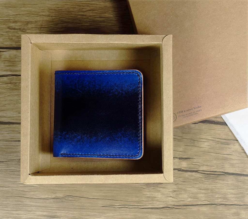 八卡短夾課程完成作品,藍色植鞣革皮革短夾放置於禮盒中,對折式設計外觀俐落,適合送禮與日常使用。