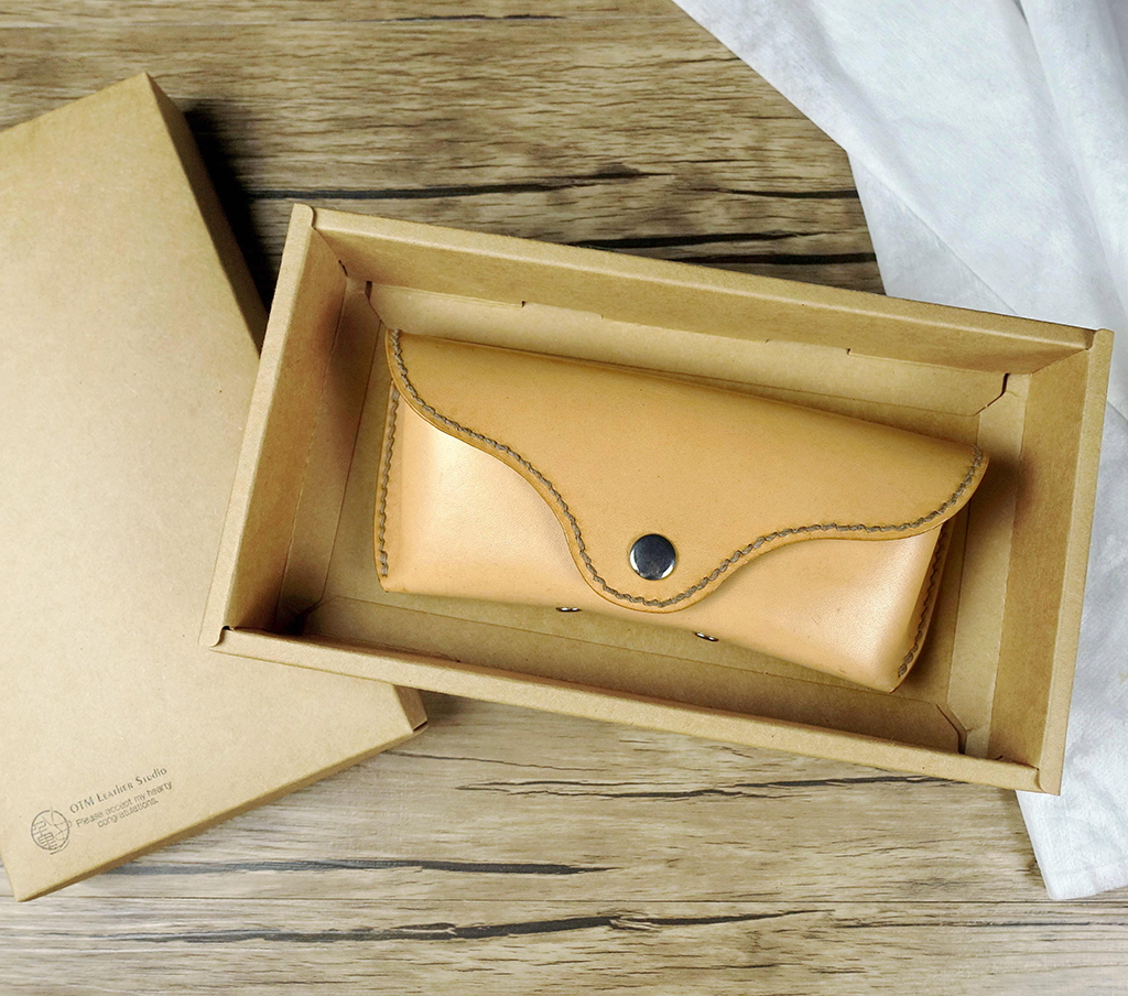 手作植鞣革眼鏡皮盒置於牛皮紙禮盒中,適合送禮使用的皮革配件成品展示。