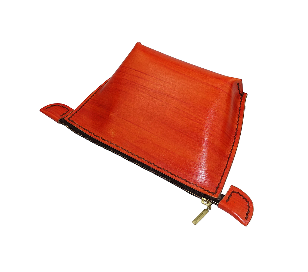 手工染色橘紅植鞣革手拿化妝包俯視角度,弧線包身自然撐開,立體厚度約6.5公分,手縫收邊細節完整呈現。