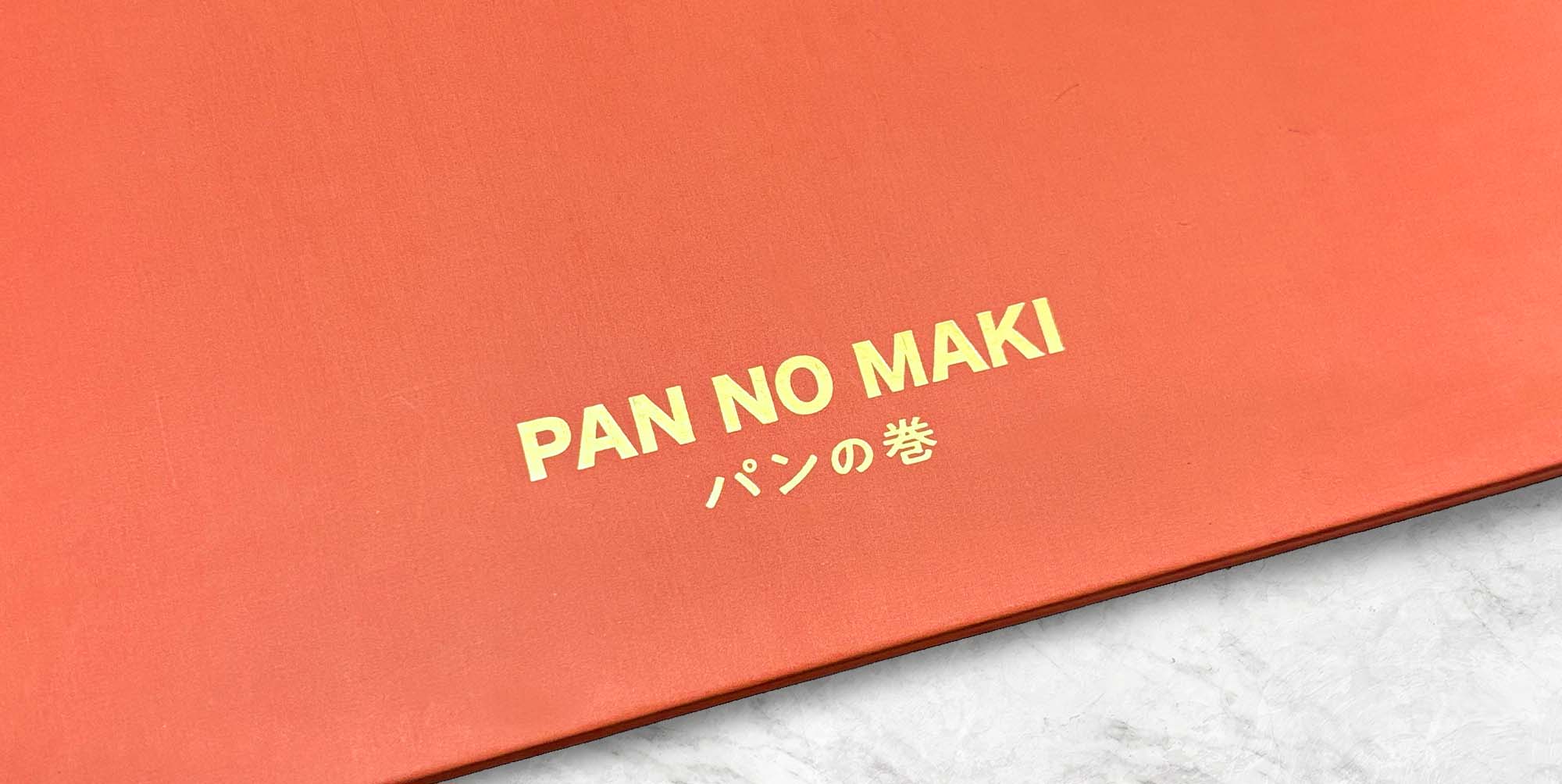 ㄆㄤˋ的故事|パンの巻 胖的故事 菜單封面燙金加工特寫,紅色精裝封面以金色品牌字樣呈現細緻質感與品牌識別。