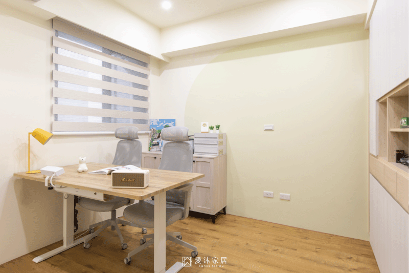 書房沿牆規劃淺木色系統書櫃,結合封閉式收納與開放展示層架,兼顧書籍、收藏與生活用品收納