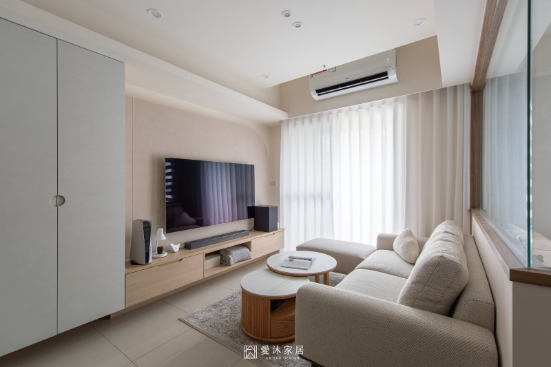 明亮客廳空間以米白系統櫃、木質電視櫃與弧形電視牆打造溫馨居家氛圍