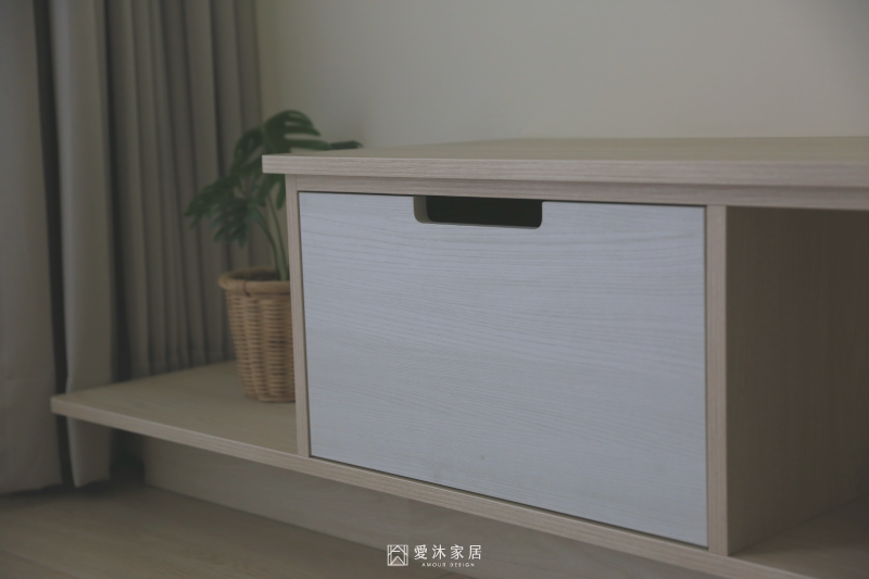 客廳電視櫃抽屜採用挖孔把手設計，搭配淺木色與白色木紋呈現簡潔細節