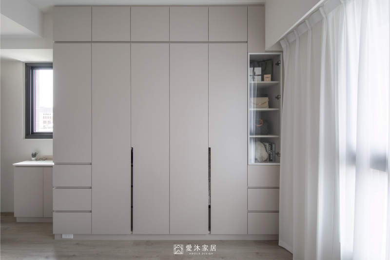 主臥系統衣櫃設計,整面頂天衣櫃結合抽屜與玻璃展示櫃,兼顧衣物收納與包包展示