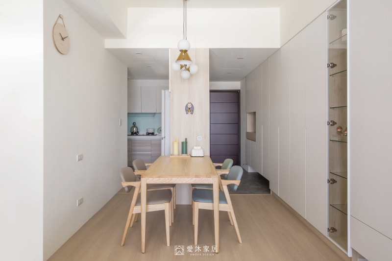 北歐風餐廳以淺木色實木餐桌椅搭配系統收納櫃，串聯玄關、餐廳與廚房空間