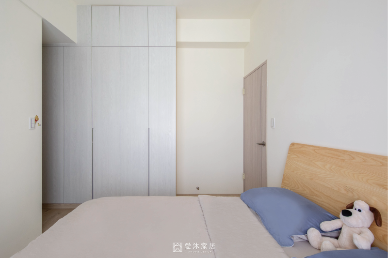 北歐風主臥以淺木質床架搭配白色木紋系統衣櫃，營造簡潔溫潤的休息空間