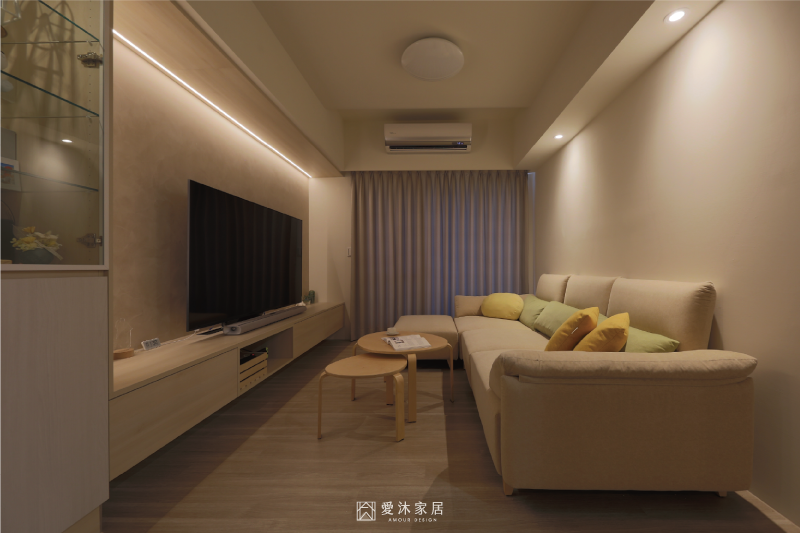 客廳電視牆結合間接照明與淺木色懸浮電視櫃,營造溫暖放鬆的夜間氛圍