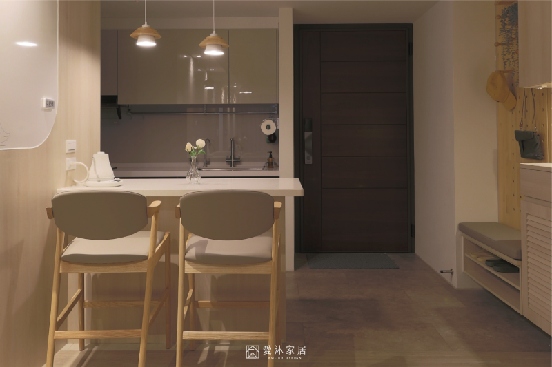 開放式餐廚空間以中島延伸吧台座位,搭配木質高腳椅增加用餐與互動機能
