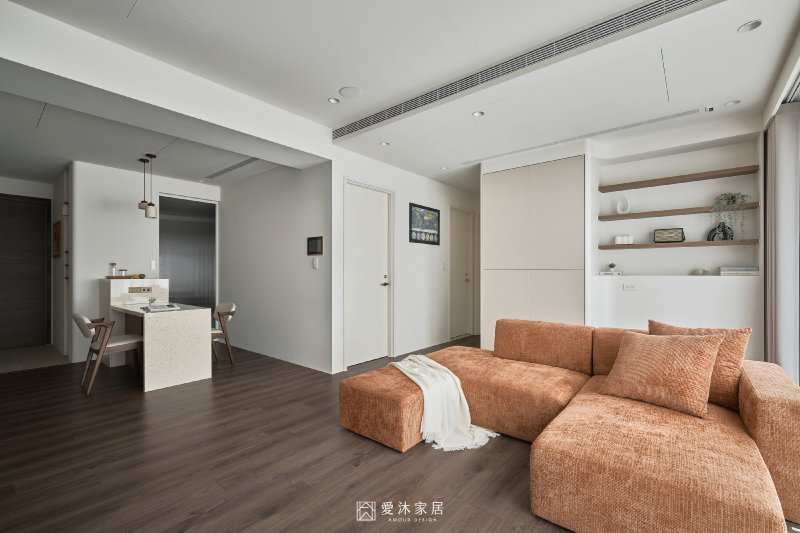 開放式客廳以焦糖色沙發作為空間視覺焦點,拆除隔間後串聯中島與公共區域,放大整體採光與活動範圍