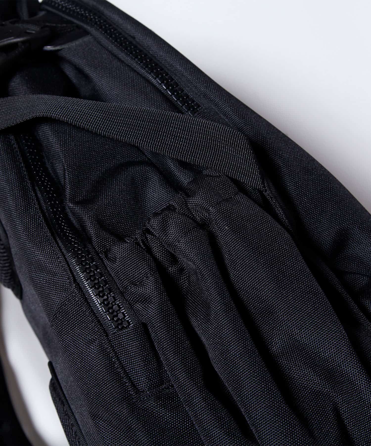 模特兒佩戴旅行後背包黑色款的圖片，精緻拉鍊