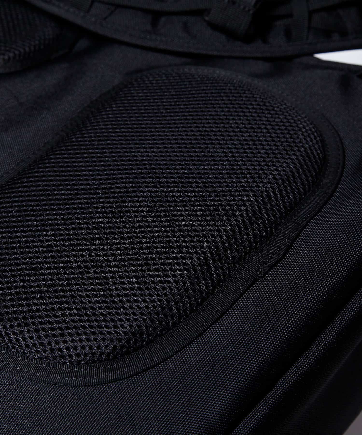 模特兒佩戴旅行後背包黑色款的圖片，背部紓壓氣墊