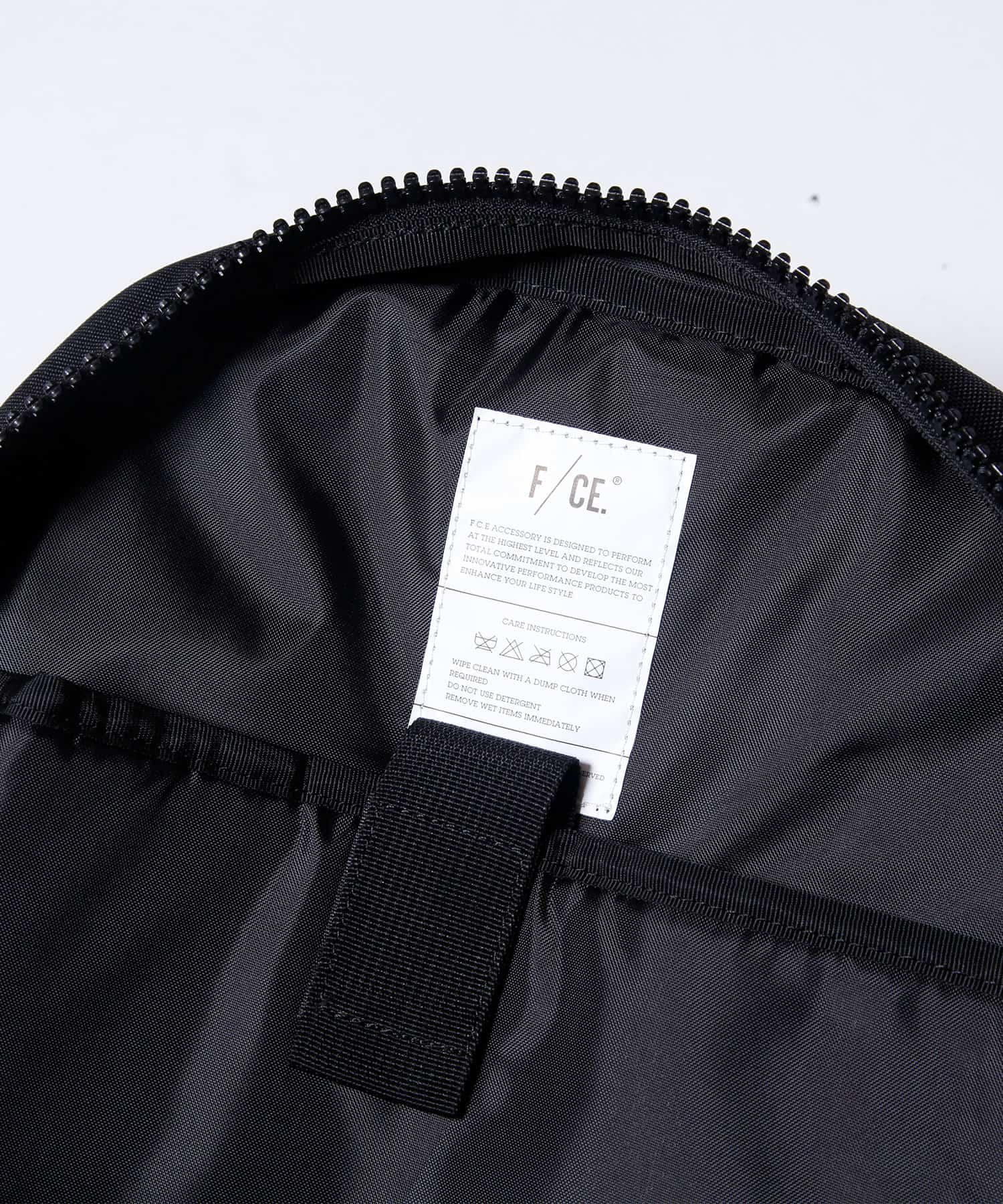 模特兒佩戴旅行後背包黑色款的圖片，內部標籤洗滌籤