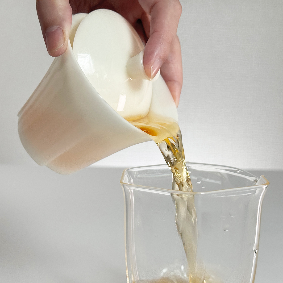 手持蓋碗優雅出湯的畫面