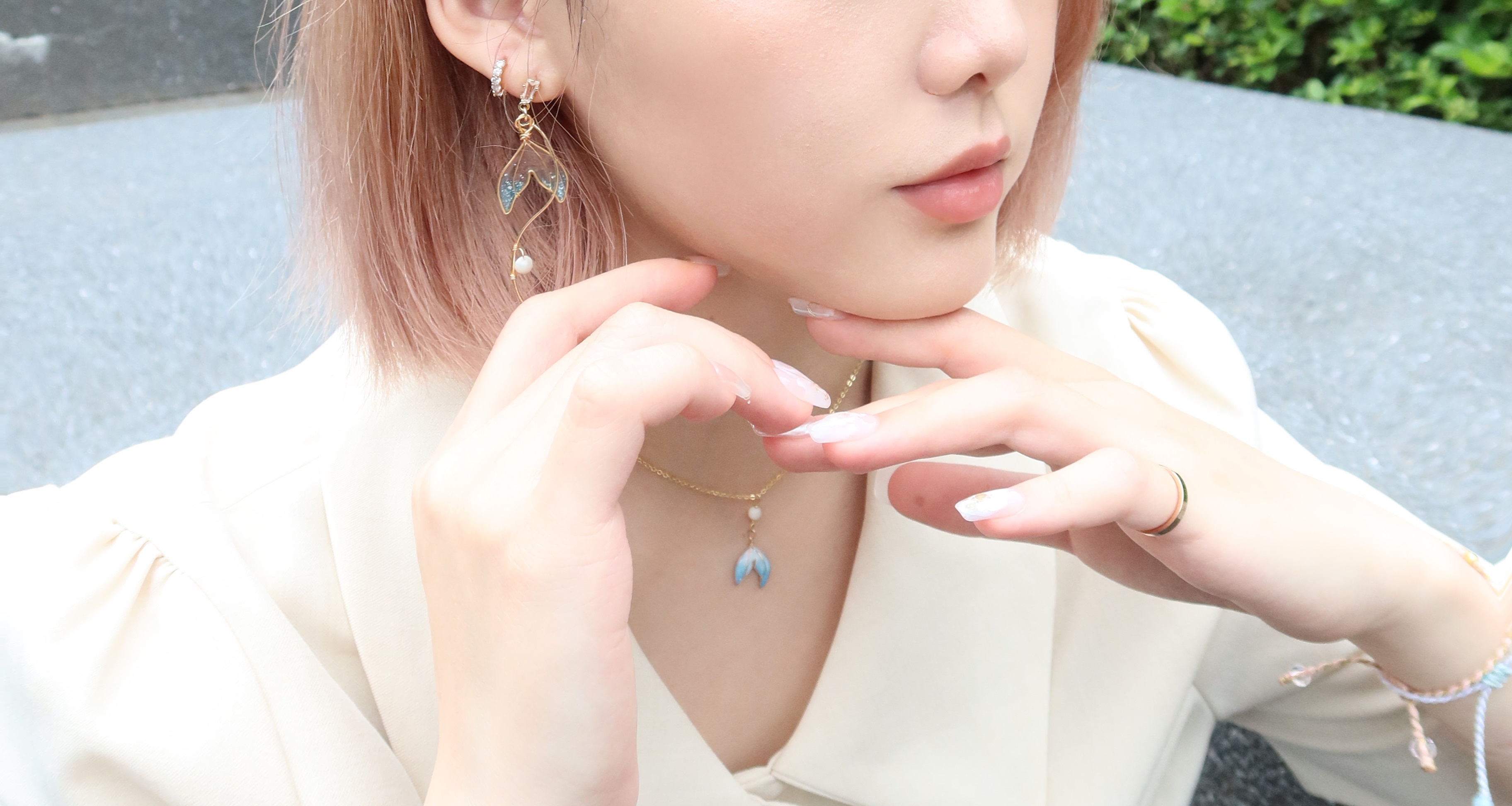 將獨家設計的斑斑耳夾溫柔地戴上耳垂的動作示範。